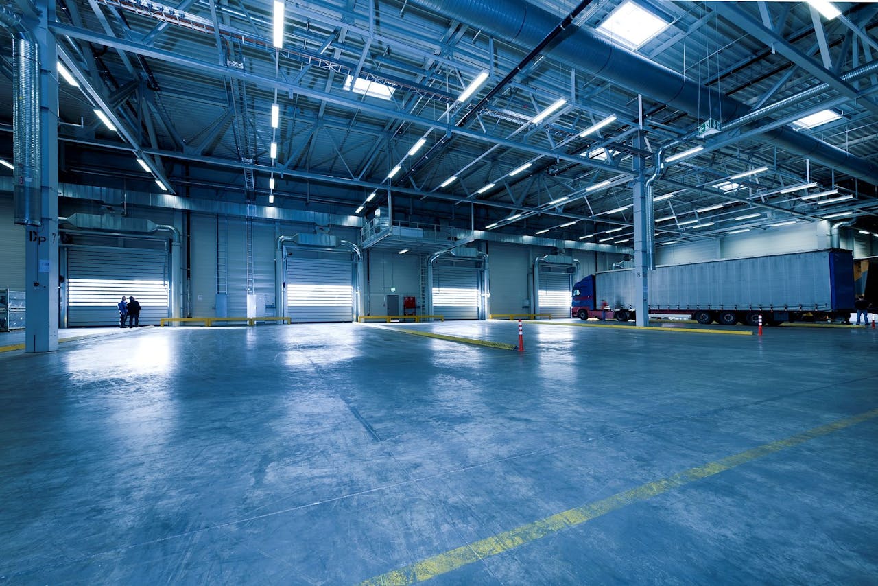 cta-bg Large warehouse interior with docked truck, ideal for logistics and warehousing.